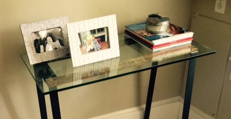 closeup glass topped table with custom metal legs